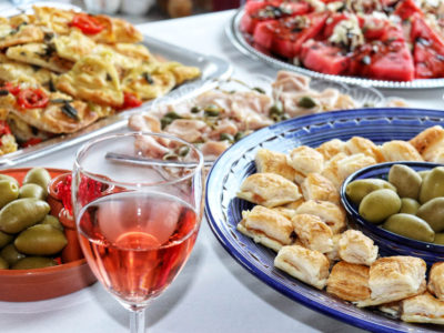 Italian catering buffet with mortadella, olives and rose wine