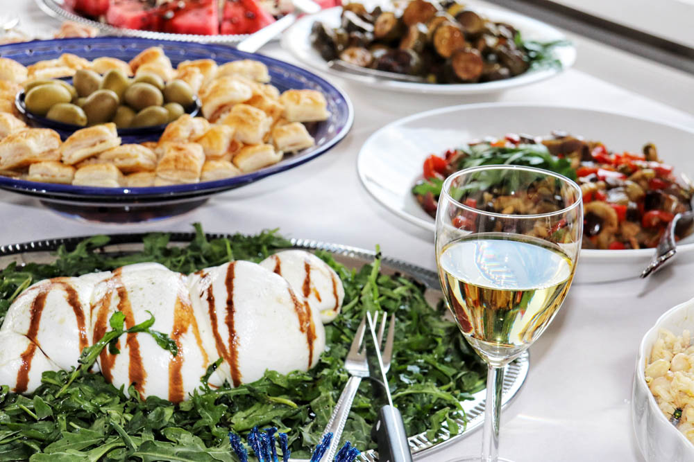 Italian catering buffet with mozzarella, olives and white wine
