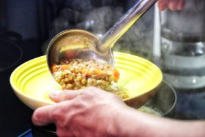 Linseneintopf serviert mit einer Suppenkelle