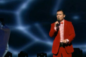 Alessandro Cipriano on stage wearing a red suit